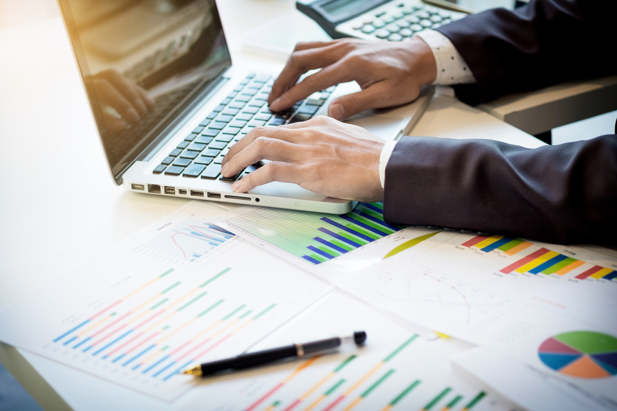 Working process startup. Businessman working at the wood table with new finance project. Modern notebook on table. Pen holding hand.